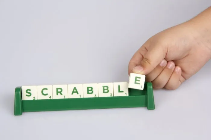 konak,İzmir,turkey- june 15, 2014  a kid's hand putting scrabble letter tile on the board and scrabble distributed by mattel