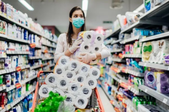 toilette paper shortagewoman with hygienic mask shopping for toilette paper supplies due to panic buying and product hoarding during virus epidemic outbreakhygiene products deficiency