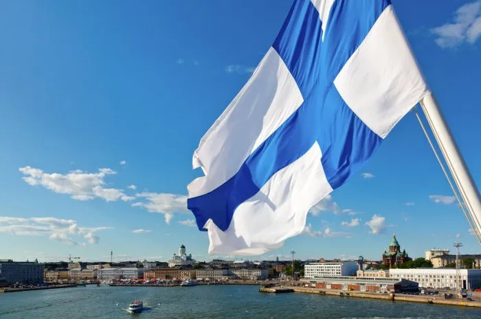 flag of finland against helsinki panorama