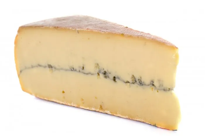 slice of french cheese morbier in front of white background