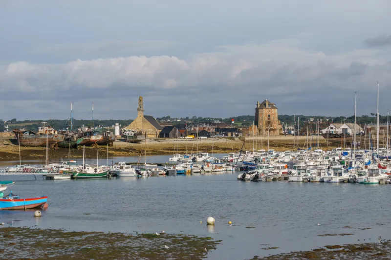 port of camaret-sur-mer with sailing boats on the water surface and church and tower, crozon peninsula, finistere, brittany, france