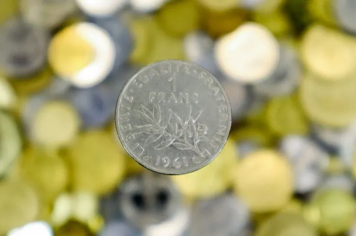 a close-up shows one 1 french franc coin from 1961 this is money blurred money background sower type mint - paris made from nickel