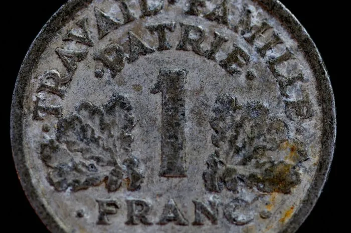 1942 1 franc vichy french state - light type coin reverse side,oak leaves either side of the central numeral, lettering above, lettering below with the datelettering  travail·famille· ·patrie· 1 ·franc·1942