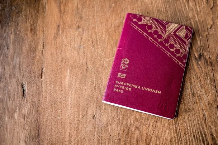 swedish passport folded on wood rustic background