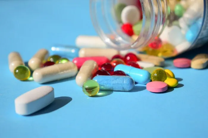 medicines banned, pills recall multicolored bright various type pills and capsules spilling out of a toppled white pill bottle