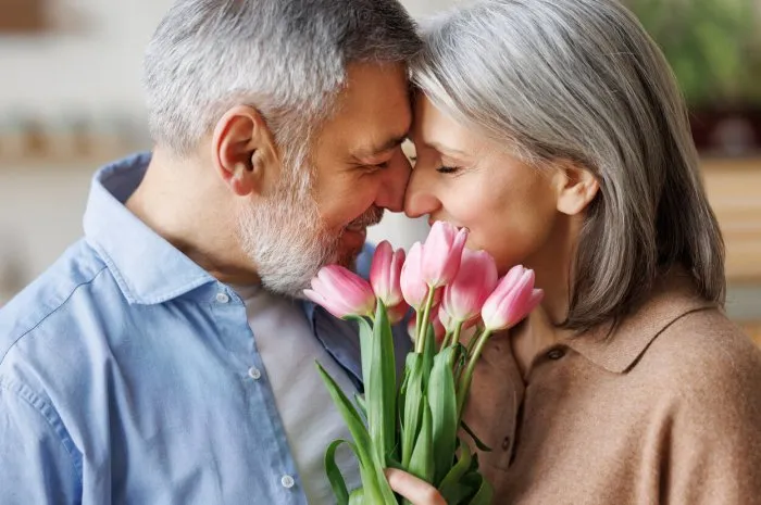 elderly couple in love hugging on valentine's day a loving senior husband gives his wife a tender bouquet of tulip flowers
