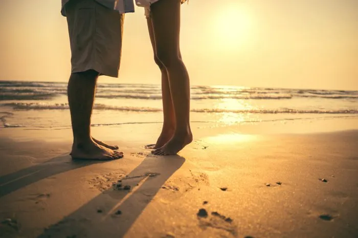 imagine couple hugging and kissing on the beach