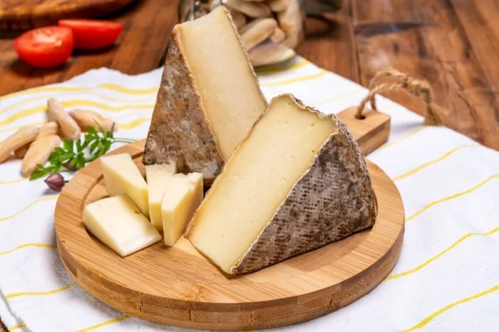 pieces of cheese tomme de montagne or tomme de savoie made from cow milk in french alps