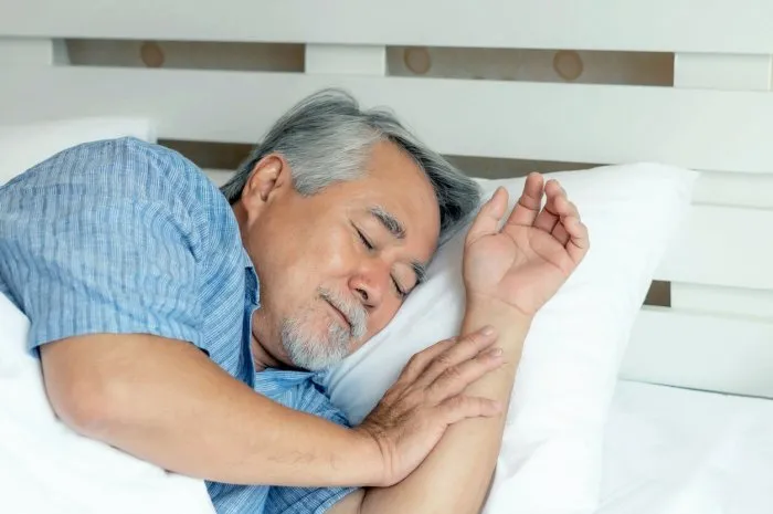 senior male , old man sleeping on the pillow on white bed in the morning - lifestyle senior male good health concept