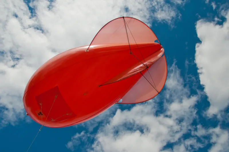 red weather balloon with white clouds