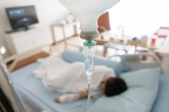 little boy get sick from influenza need to be admitted to hospital with saline intravenous (iv) in-line hand pressure