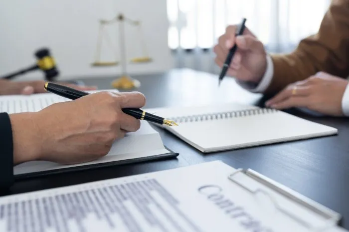 law,libra scale and hammer on the table, 2 lawyers are discussing about contract paper, law matters determination, showing paper and notes