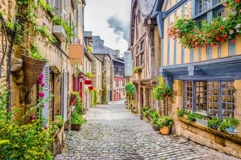 beautiful view of scenic narrow alley with historic traditional houses and cobbled street in an old town in europe with blue sky and clouds in summer with retro vintage instagram grunge filter effect