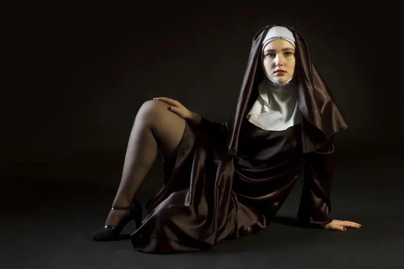 nun laying exposing leg photo on black background