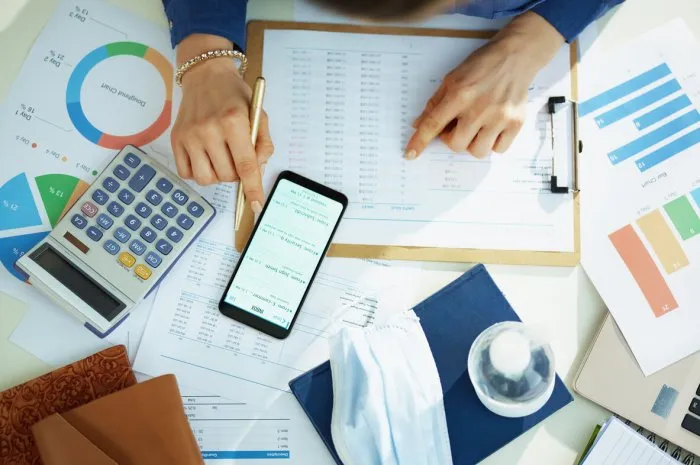 upper view of middle age business woman at the table checking emails on a smartphone