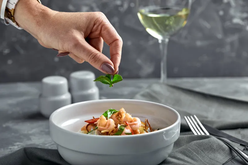 rice noodles with shrimps and seafood with female hand, spicy asian style noodles in bowl