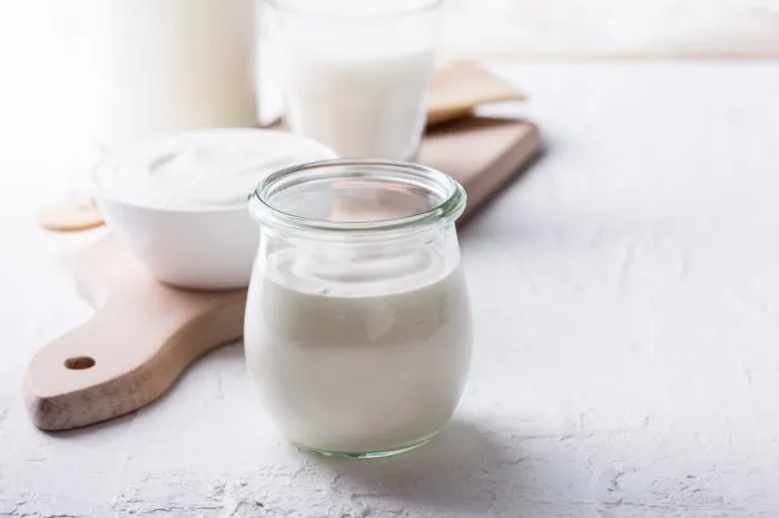 homemade organic sour cream in glass jar on rustic table