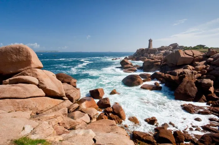 lighthouse in the rocks on pink granite coast in france