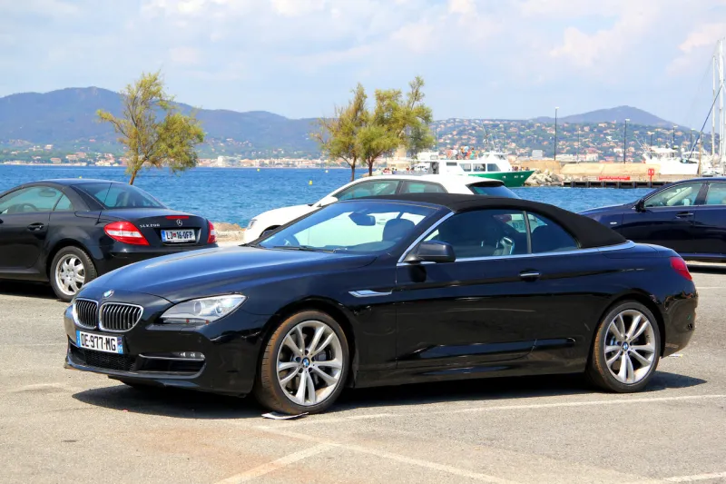 saint-tropez, france - august 3, 2014  black convertible sports car bmw f12 6-series parked at the city street