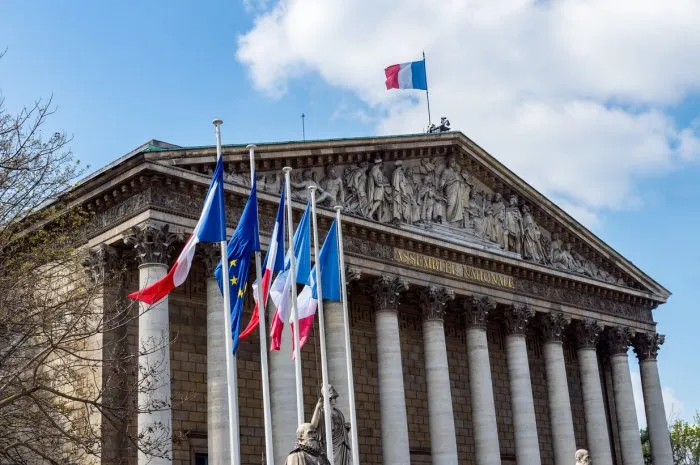 paris, france  french and european union flags in the wind in front of national assembly