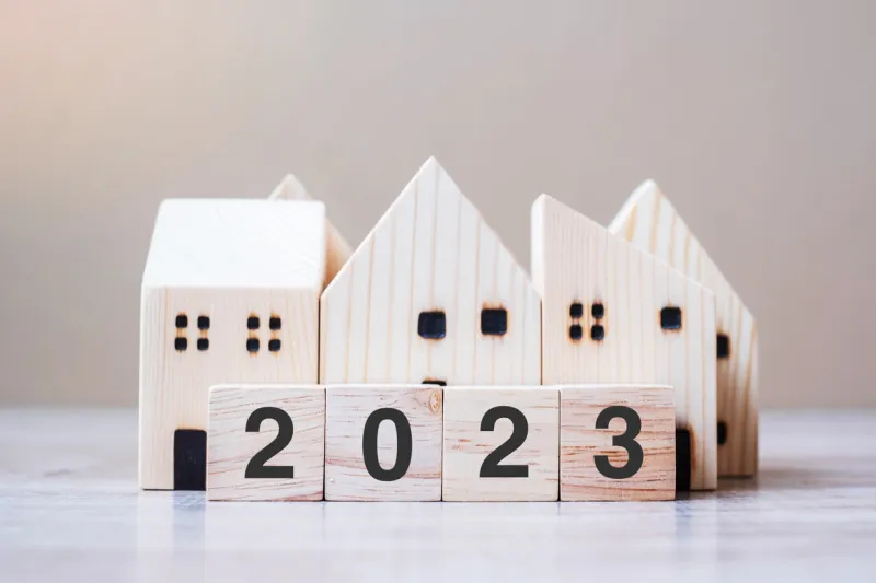 2023 happy new year with house model on table wooden background banking, real estate, investment, financial, savings and new year resolution concepts