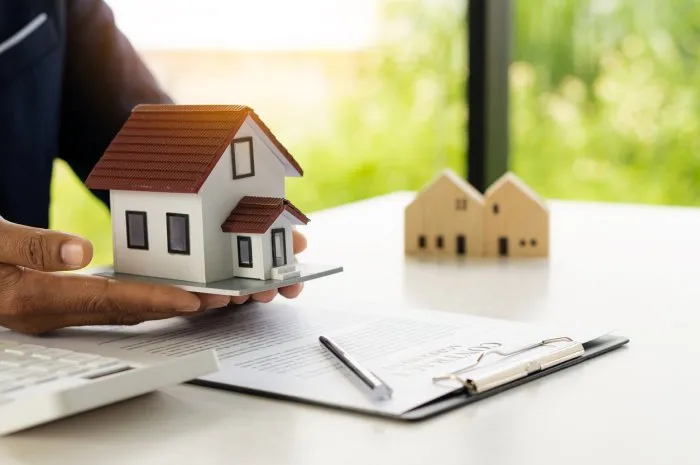 a real estate agent offers a sample home insurance home to sign the agreement with documents of the contract of sale or lease