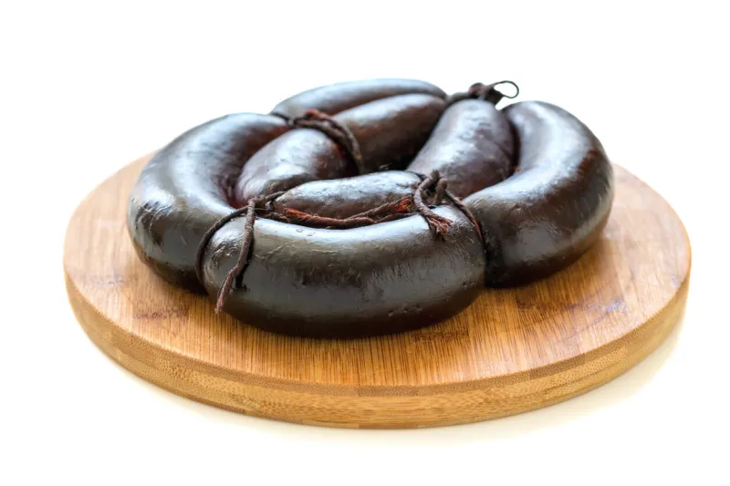 wooden stand with black pudding on a white background