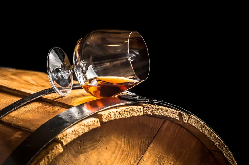 glass of cognac on the old wooden barrel