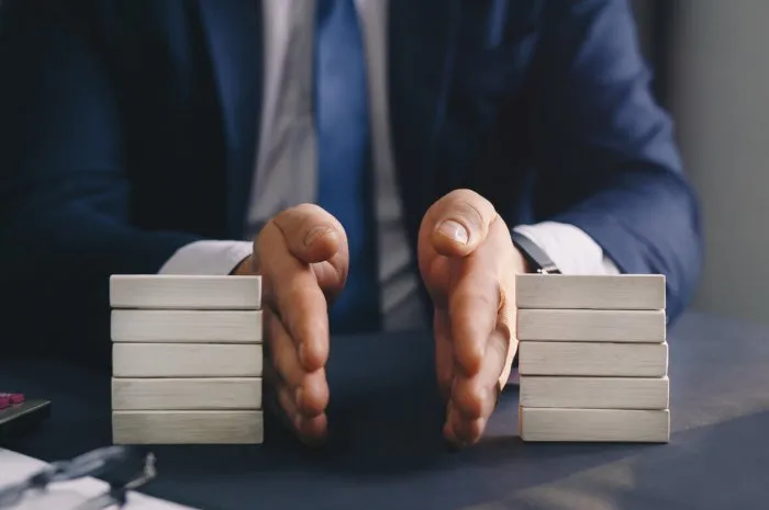 businessman separates wooden block concept of wealth equality division of property divorce and legal services