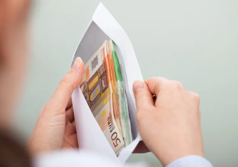 close-up of person checking out envelope with cash