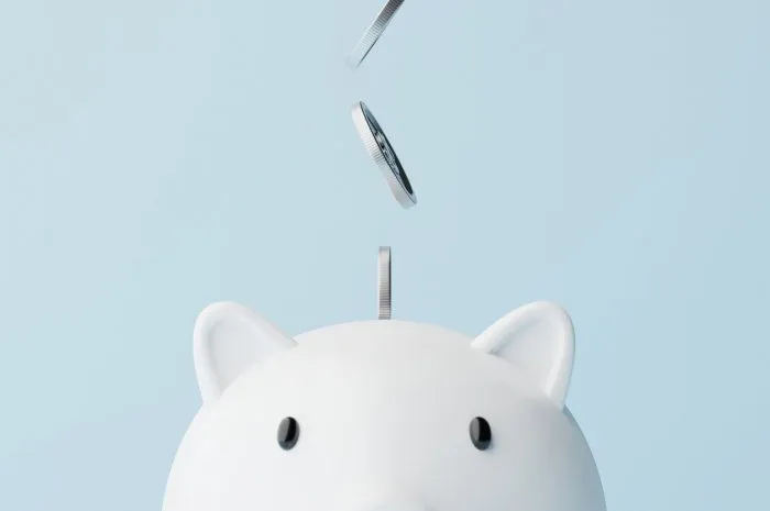 save money and investment concept closeup piggy bank and silver coins falling 3d rendering illustration