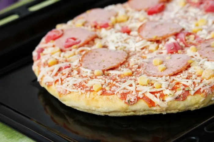 frozen pizza with salami, cheese, corn and pepper