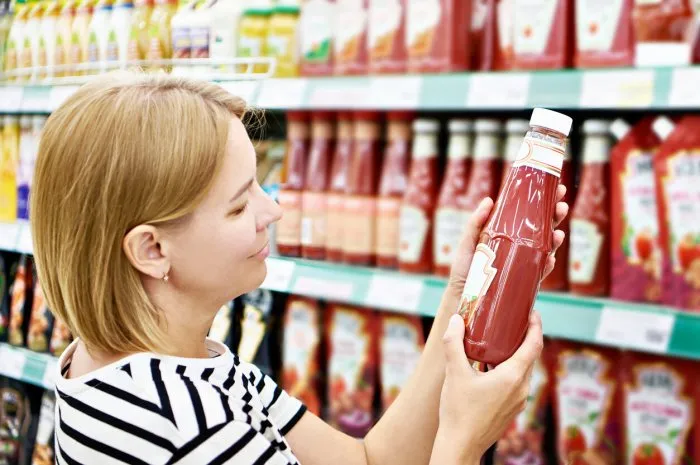 packing of tomato ketchup in hands woman
