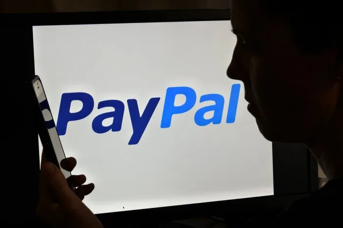 brisbane - oct 16 2022 silhouette of upset australian woman over paypal logopaypal has backtracked on a published policy that would have fined users 2,500 for spreading misinformation online