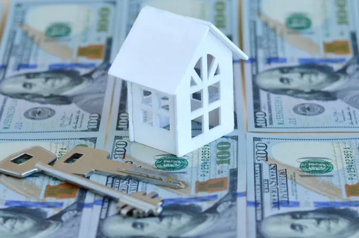 rising house prices, rising mortgage ratesthe house stands on american dollars nearby are the keys to the apartment home expenses or investing concept