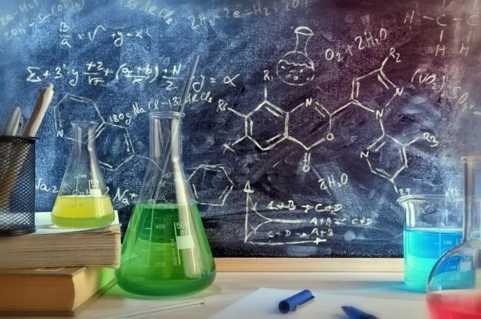 classroom desk and drawn blackboard of chemistry teaching with books and instruments chemical sciences education concept horizontal composition front view