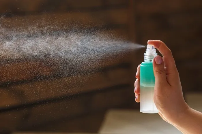 a woman hand spraying hydrating spray