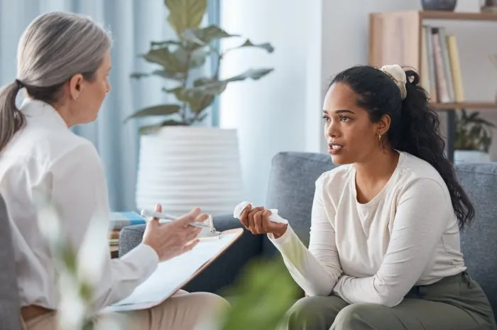shot of an attractive young woman sitting and talking to her psychologist during a consultation