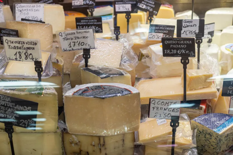 different types of cheeses in a delicatessen with signs in spanish
