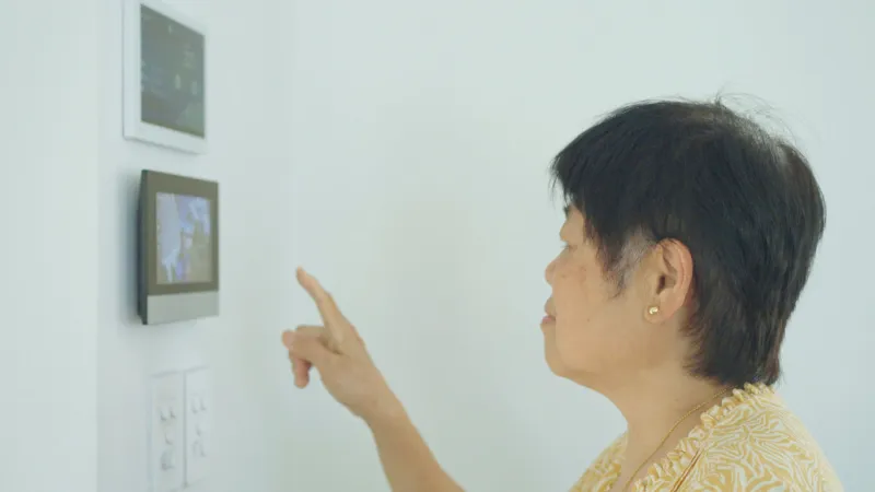 senior asian woman unlocking front door through smart device at home, elderly woman using technology