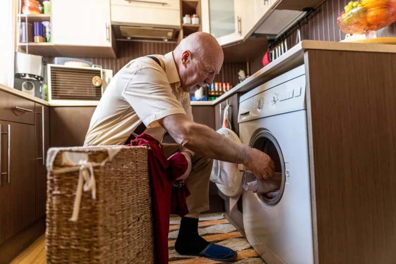 senior man doing the laundry at home