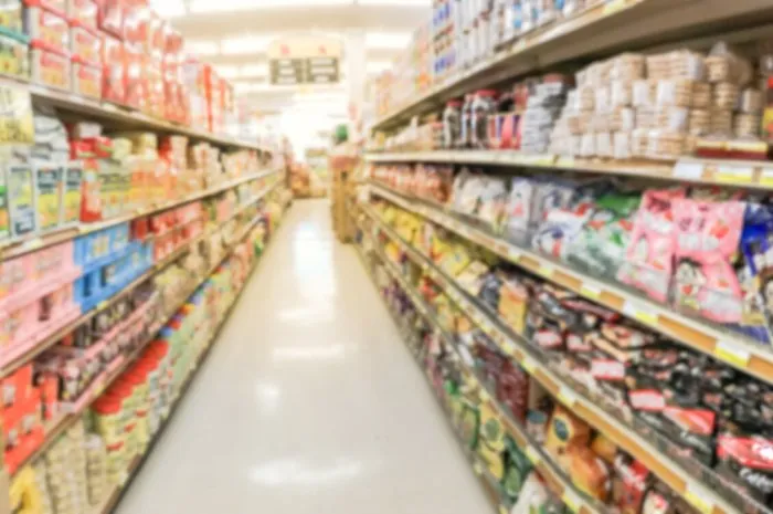 panorama view blurred abstract candy, cookies, beef jerky, snack time at asian grocery store in garland, texas, usa defocused sweet treats aisle on display with price tags at department supermarket