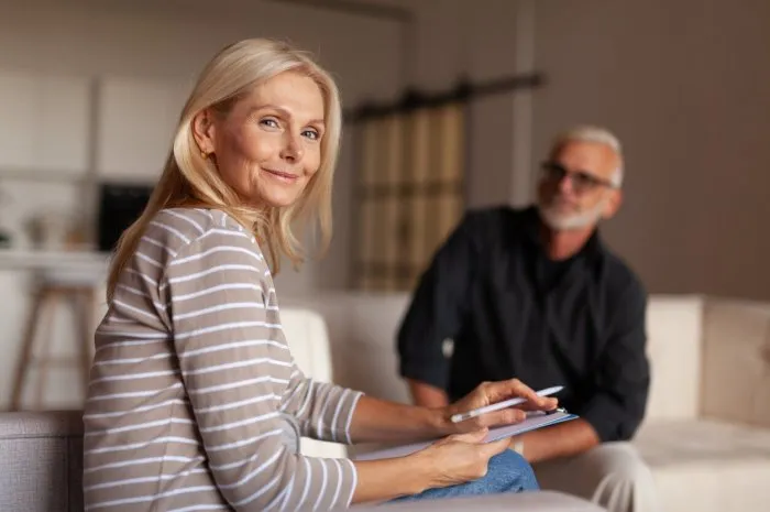 woman psychologist smiling at a psychotherapy session helping a mature man with depression and burnout