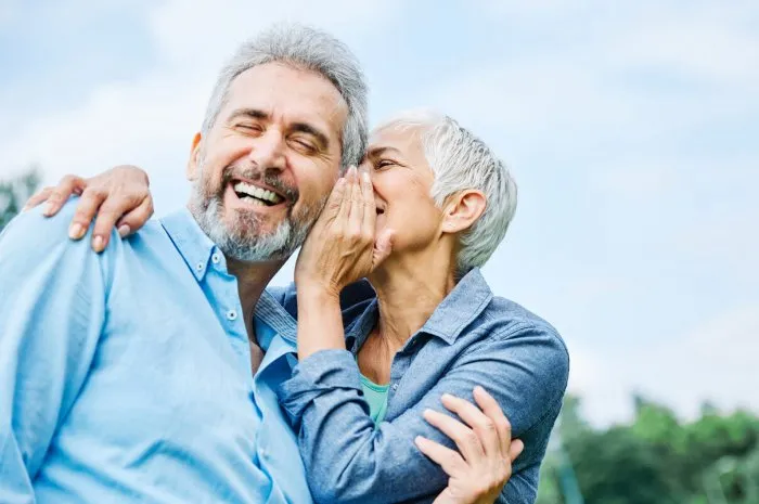 senior couple happy elderly love together retirement lifestyle smiling man woman mature ear gossip secret whispering whisper