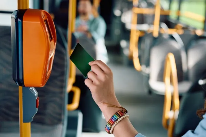 close up of woman using travel card while riding in a bus