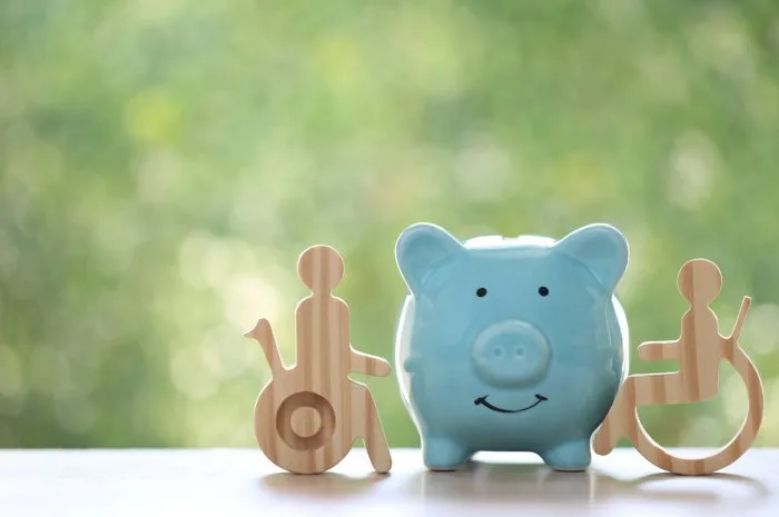 man on wheelchair and piggy bank on natural green background,save money for medical insurance and health care concept