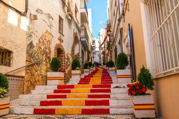 stairs of a street of calpe in alicante painted with the colors of the national flag