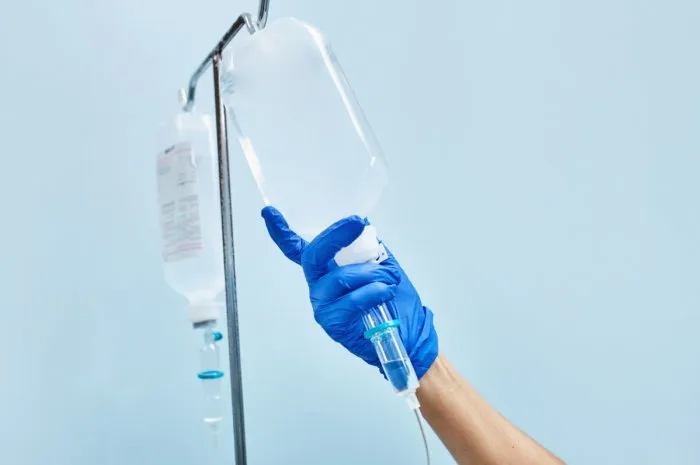 nurse's hand preparing an intravenous drip