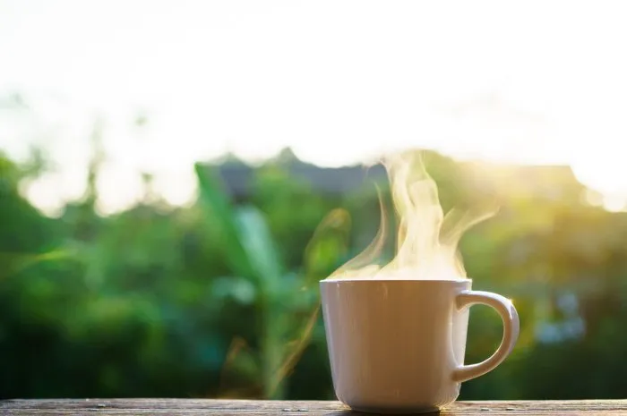 beautiful sunrise lighting in the morning with a hot coffee and moka pot close up with copyspace beautiful natural sun lighting bokeh and coffee cup in the morning