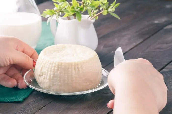 fresh feta cheese with milk and bread on a wooden table